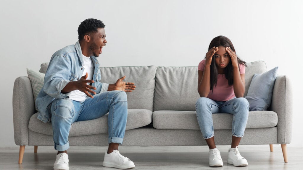 A man yelling at a woman who has her head in her hands