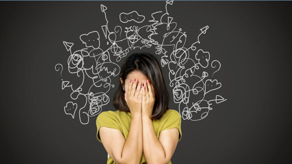 woman with hands covering her face with messy lines coming off her.