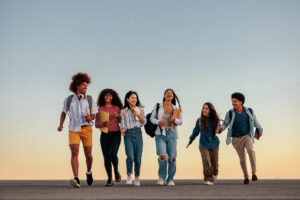 A group of students laughing and walking together between classes to show a type of secondary socialization